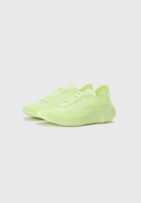 Lime green athletic shoes with a knitted texture, flat laces, and a white logo. Features a flexible sole and rounded toe design.