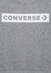 Felpa grigia realizzata in tessuto misto cotone, caratterizzata da una grande stampa bianca "CONVERSE" e un logo a stella sul davanti.