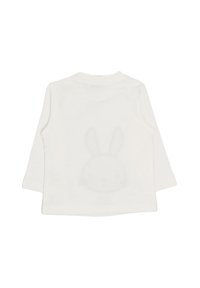 Camicia bianca a maniche lunghe realizzata in tessuto morbido, con un discreto design a faccia di coniglio sulla parte posteriore. Design semplice e minimalista.