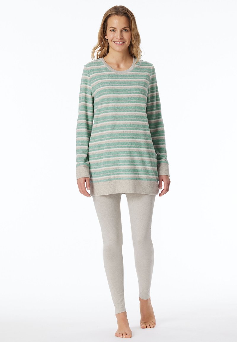 Randig långärmad tunika i grön och beige, matchad med ljusgrå leggings. Mjuk tyg, avslappnad passform, kontrasterande fåll. Avslappnad hemmaklädsel.