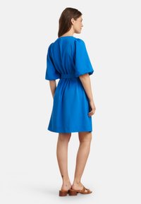 Blauwe jurk met korte mouwen, een getailleerde taille en een uitlopende rok. Glad stof en eenvoudig ontwerp, met een ronde halslijn en een middenlengte.