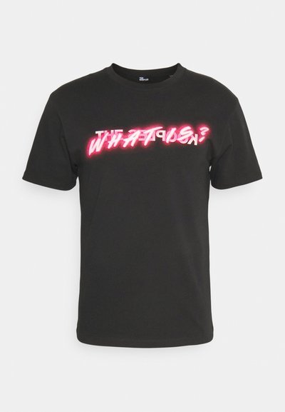 Black cotton t-shirt featuring bold white and pink graphic text "THE WHAT IS?" in a neon-style font. Short sleeves and round neck design.
