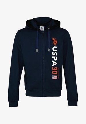 Marinblå dragkedjetröja med snoddar, USPA 90-logotyp, grafisk bild av polospelare och liten amerikansk flagga på framhöger sida.