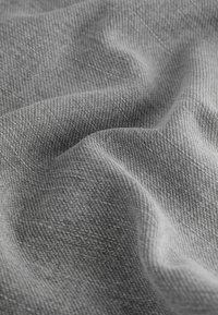 Țesătură gri țesută cu o suprafață texturată, prezentând variații subtile de nuanță și o cădere moale, potrivită pentru diverse aplicații textile.