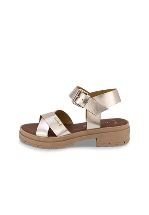 Metallic gold sandal with cross strap and dual buckle on the ankle. Brown insole and textured rubber sole. Chunky, casual design.