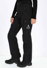 Pantaloni cargo neri con tasche con zip, ginocchia rinforzate e patch con logo. Realizzati in tessuto resistente e testurizzato. Fitti in vita.