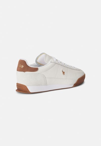 Pantof sport din piele albă cu accente din piele întoarsă, călcâi maro deschis, talpă texturată și șireturi albe. Prezintă un logo brodat pe lateral.