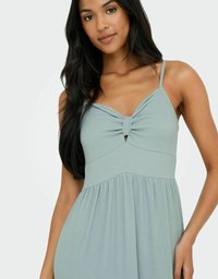 Robe sans manches vert clair avec un détail de nœud torsadé au niveau du buste et une jupe fluide et froncée. Tissu texturé avec une coupe décontractée.