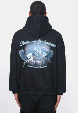 Schwarzer Hoodie mit einem grafischen Druck von zwei Vögeln, die vor einer bergigen Landschaft fliegen, mit dem Text "Bring me the horizon" darüber.