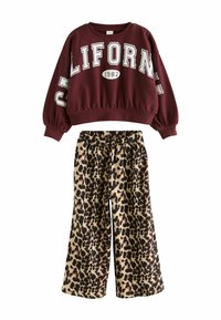 Burgunderfarbener Sweatshirt mit dem Aufdruck "CALIFORNIA 1982" und lockeren, langen Ärmeln; weit geschnittene Hose mit Leopardenmuster und elastischem Bund.