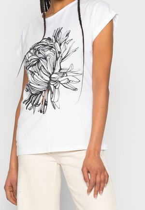 Valkoinen t-paita, jossa on lyhyet hihat ja musta kukkatoiminta edessä. Kangas näyttää sileältä ja kevyeltä.