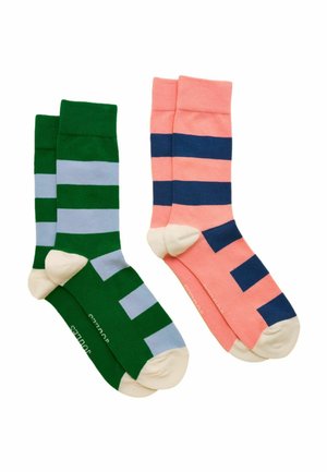 Zwei Paar gestreifte Crew-Socken: eines grün mit hellblauen Streifen, das andere korallenrot mit dunkelblauen Streifen, beide mit beigen Fersen und Zehen.