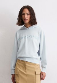 Lichtblauwe sweatshirt met een capuchon, met het geborduurde merk "Marc O'Polo" in iets donkerder blauw, gemaakt van een zachte stof.