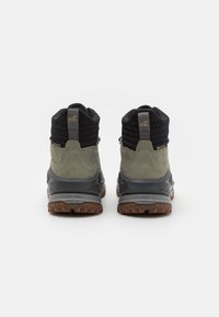 Scarpe da trekking grigie e nere realizzate in materiali scamosciati e tessili, con supporto alto alla caviglia e suole in gomma testurizzate. Accenti di logo dorato sul retro.
