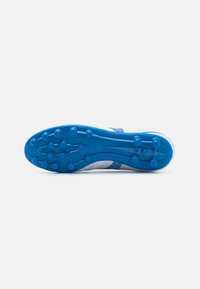 Botas de fútbol con una parte superior blanca y una suela azul. Presentan una superficie texturizada y múltiples clavos redondos para un mejor agarre.