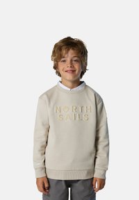 Sudadera de algodón beige con "NORTH SAILS" grabado en el centro, puños y dobladillo acanalados, combinada con pantalones cortos grises.