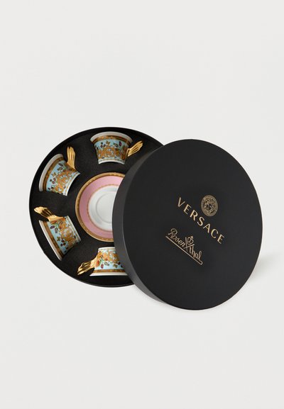 Μαύρο στρογγυλό κουτί με χρυσά λογότυπα VERSACE και Rosenthal, που περιέχει τέσσερα περίτεχνα φλιτζάνια τσαγιού με χρυσές λαβές και ροζ-χρυσό πιατάκι.