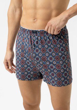 Boxer shorts featuring a blue base with a floral pattern in red, white, and blue. Made from soft fabric with an elastic waistband.