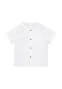 Camicia bianca a maniche corte con tessuto strutturato, colletto rotondo, taschino frontale e cinque bottoni in legno lungo la parte anteriore.