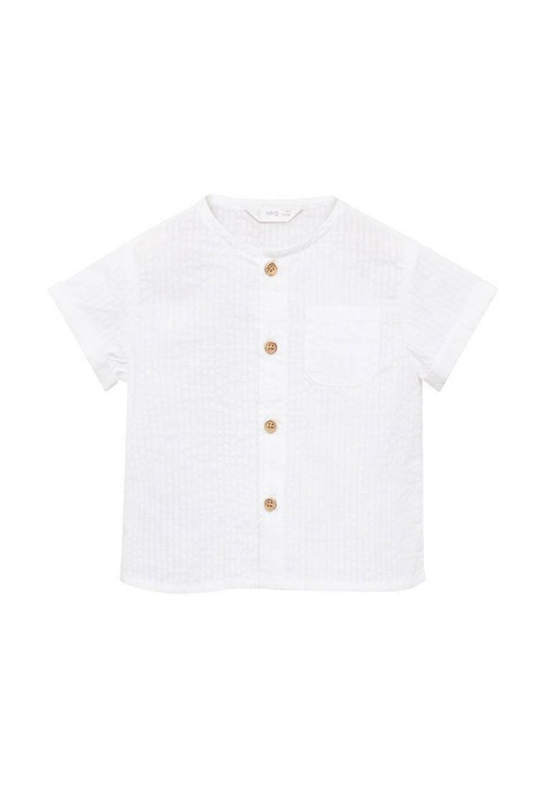 Camicia bianca a maniche corte con tessuto strutturato, colletto rotondo, taschino frontale e cinque bottoni in legno lungo la parte anteriore.