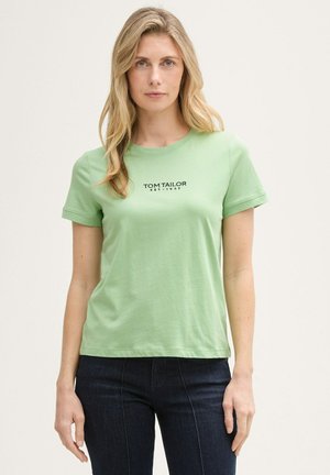 T-shirt en coton vert clair à manches courtes et col rond. Il présente le texte noir "TOM TAILOR EST. 1962" sur la poitrine.