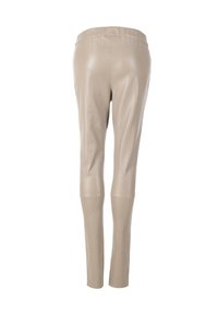 Beige læderleggings med et tætsiddende design, der har en elastisk talje og en glat tekstur, der snævrer ind ved anklen uden synlige sømme.