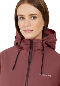 Maroon waterproof jacket with a high collar, front zipper, and adjustable black drawstrings. Features logo "D. DRIKSONS" in white.