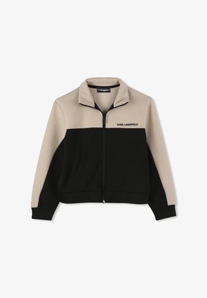 Jas met rits en een kleurgeblokte ontwerp in beige en zwart. Gemaakt van zacht materiaal met een opstaande kraag en geborduurd logo.
