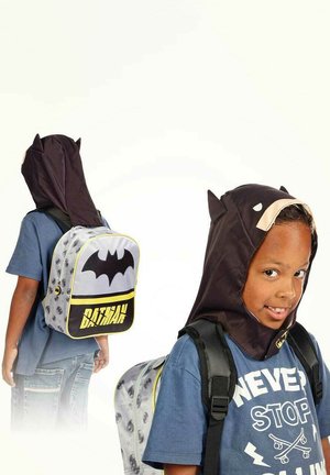 Mochila temática de Batman en gris con acentos en negro y amarillo; cuenta con una capucha con orejas de murciélago y gráficos estilo cómic. Correas ajustables.