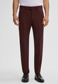 Bordeaux op maat gemaakte broek met een slank ontwerp, voorzien van een platte voorkant, zijzakken en een gladde textuur. Gepaard met zwarte nette schoenen.
