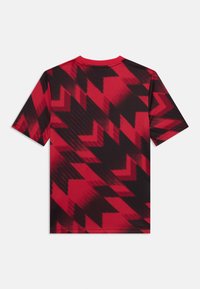 Kortärmad t-shirt i röd och svart, med ett zickzackmönster. Tillverkad av ett mjukt, andningsbart tyg med rundad halsringning.