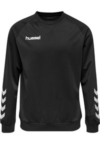 Black sweatshirt made of smooth fabric featuring long sleeves, a crew neck, and white chevron patterns on the sides. Hummel logo displayed.