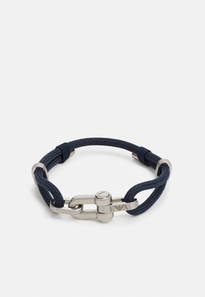 Braccialetto in corda intrecciata blu navy con fibbia a grillo in metallo argentato inciso con il logo "EA" su sfondo bianco.