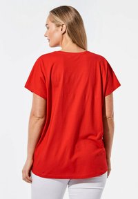 Rode katoen t-shirt met een ontspannen pasvorm, korte mouwen en een ronde hals. Gladde textuur en geen zichtbare patronen of hardware details.