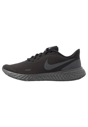 Sort Nike løbesko med tekstureret mesh-overdel, sort swoosh-logo, polstret sål og snørelukning.