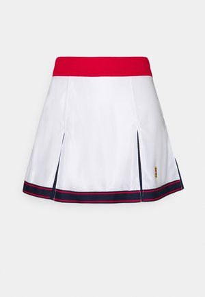 Falda de tenis blanca con cintura roja, dobladillo a rayas azul marino y rojo, y tablas laterales sobre fondo gris claro.