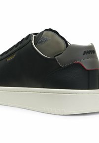 Μαύρο και γκρι sneaker χαμηλού ύψους με λευκή σόλα, χρυσό λογότυπο "Hugo", μαύρα κορδόνια και ραμμένες λεπτομέρειες στο πέλμα με κόκκινη λεπτομέρεια.