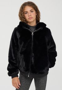 Giacca nera in pelliccia sintetica con cappuccio, chiusura con zip, polsini e orlo a coste, texture morbida e vestibilità comoda. Design leggero e accogliente.