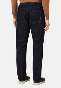 Temno modri jeans s ravnim krojem, ki imajo dve zadnji žepki in subtilno teksturo. Pas ima več detajlov šivanja.