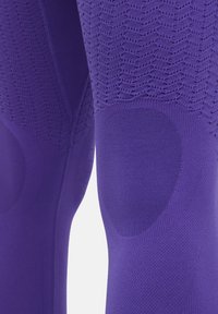 Leggings viola con un motivo testurizzato, zone del ginocchio rinforzate e tessuto liscio con un design aderente.