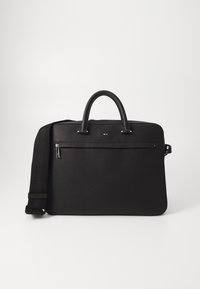 Sac en cuir noir avec une texture lisse, deux poignées supérieures et une bandoulière amovible. Il dispose d'une poche avant zippée et de détails de logo.