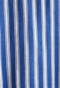 Blue and white striped fabric texture, with vertical lines in varying widths, made of lightweight material, showing a woven pattern.