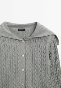 Gray cable-knit cardigan featuring a wide collar, five silver buttons, and textured fabric. Label reads "Massimo Dutti."