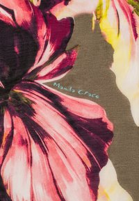 Tessuto floreale con grandi e vivaci motivi di fiori rosa e gialli su uno sfondo verde tenue, con etichetta "Manila Grace" in azzurro chiaro.