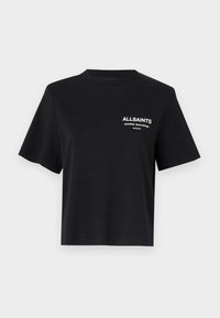 Camiseta de algodón negra con escote redondo y mangas cortas. Presenta texto impreso en blanco en la parte izquierda del pecho. Corte simple y relajado.