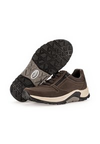 Chaussures de sport marron avec une semelle en caoutchouc texturée, dotées d'une fermeture éclair et de détails de couture contrastants sur un matériau semblable au daim.