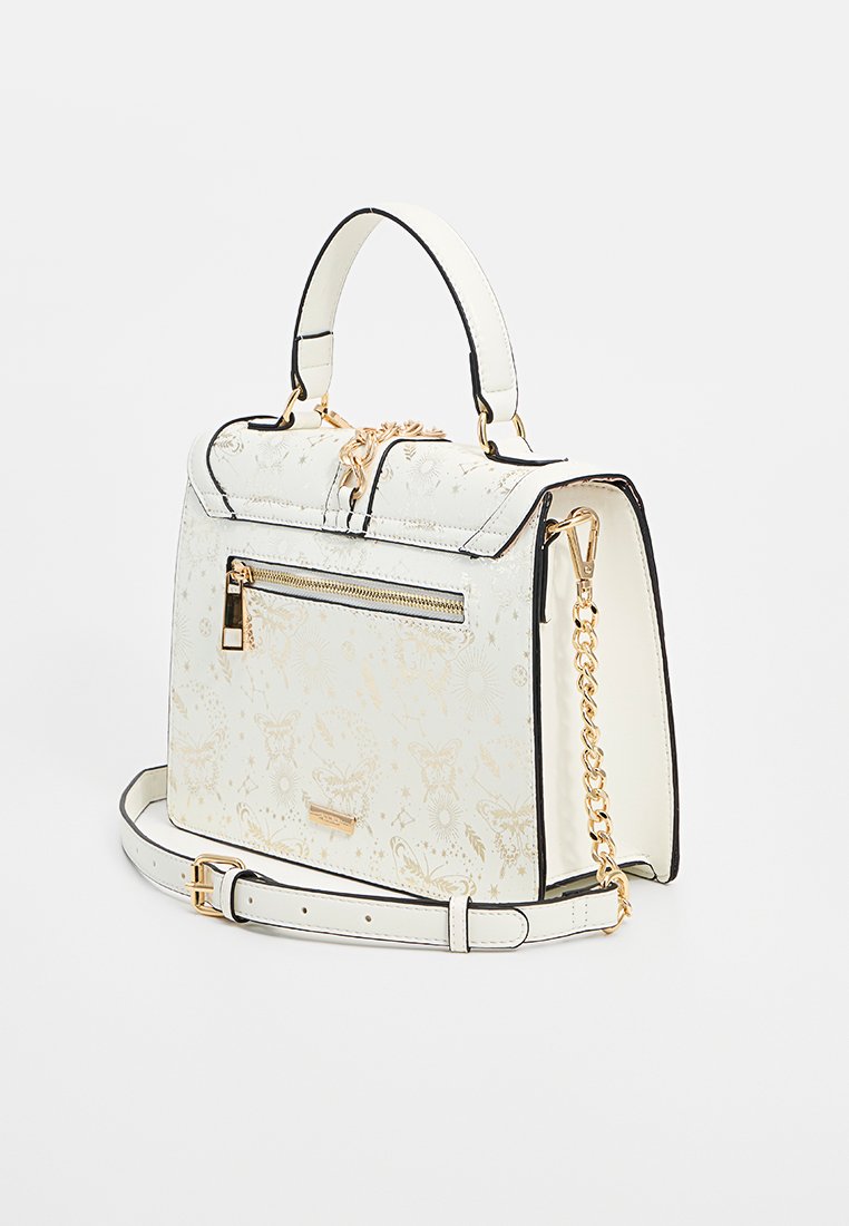 Sac à main blanc avec des motifs de papillons et de fleurs dorés, poche zippée dorée, anse supérieure, bandoulière amovible et détail en chaîne sur fond uni.