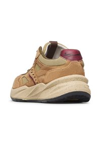 Zapatillas de ante en tono suede con detalles en oliva, tabique en marón en el talón y entresuela texturada en crema con suela de goma negra. Diseño alternativo de cordones.