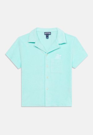 Camisa azul claro de manga corta con botones, cuello, bolsillo en el pecho y pequeño diseño bordado de tortuga encima del bolsillo.