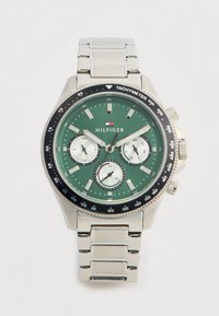 Tommy Hilfiger rozsdamentes acél karóra zöld számlappal, három fehér segédszámlappal, tachyméter kerettel, valamint dátum-, nap- és 24 órás kijelzőkkel.